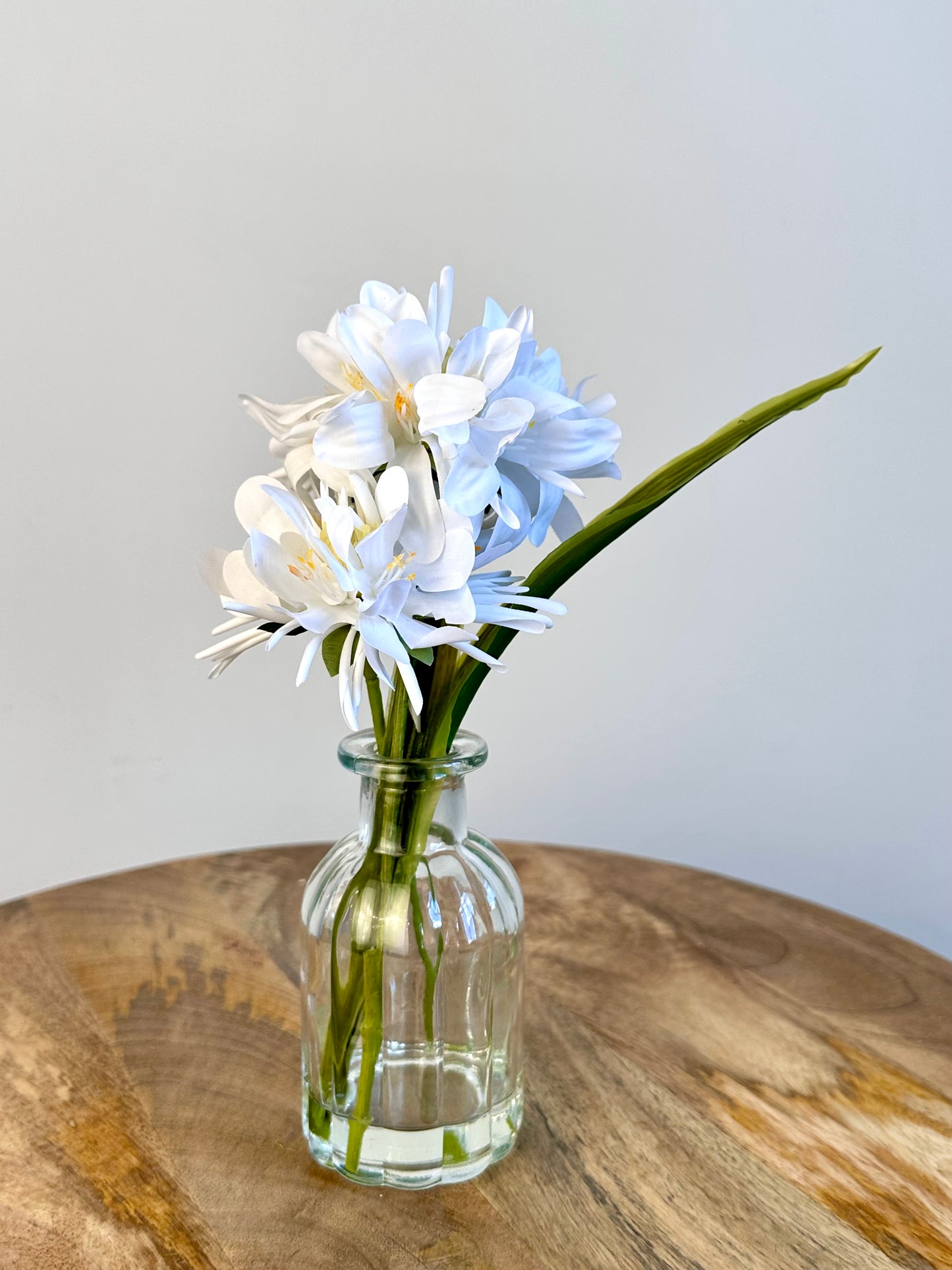 White Floral Display In Clear Glass Ribbed Jar 21cm